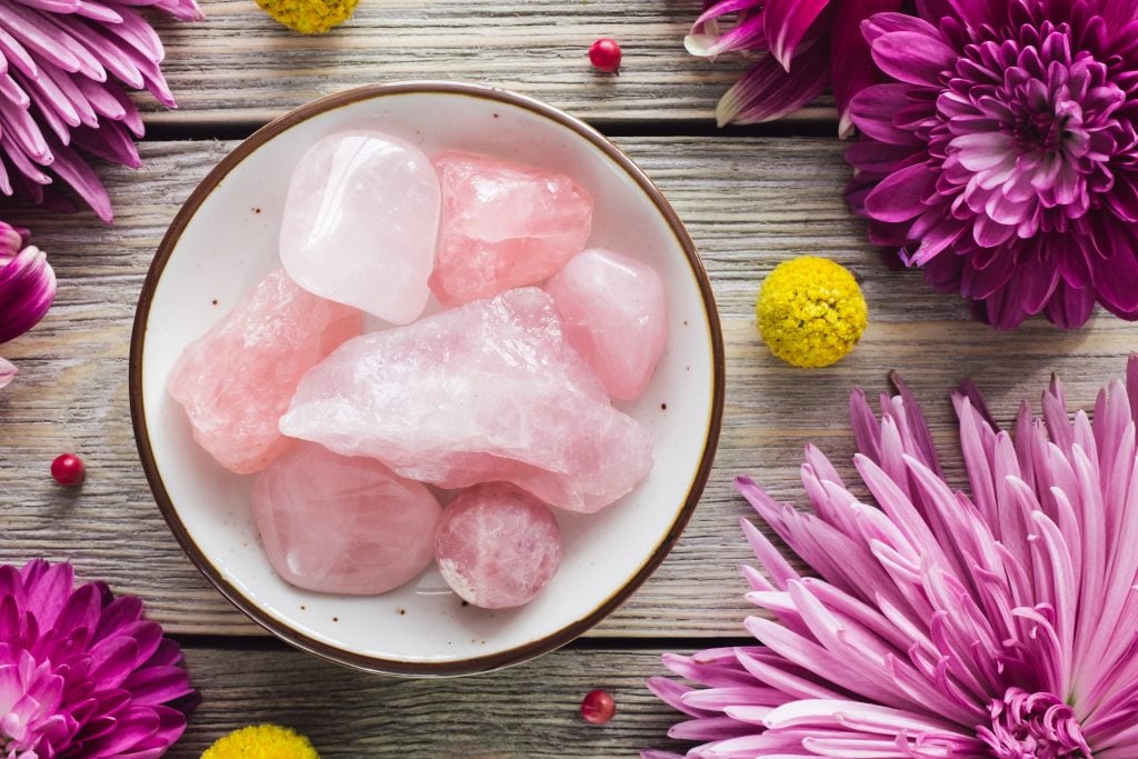 rose quartz on table with chrysanthemum