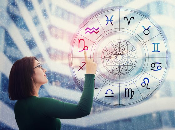 Woman choosing a zodiac sign from the astrological wheel to find the future predictions. Having trust in horoscope, consulting stars and believe in the power of universe. Astrology esoteric concept.