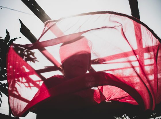 woman looking through red scarf