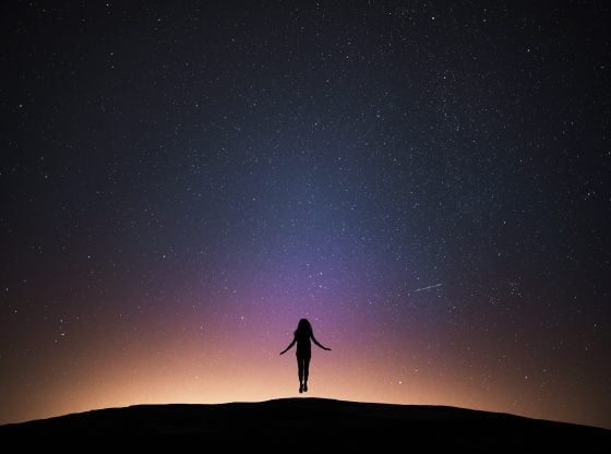 Woman flying with night sky.