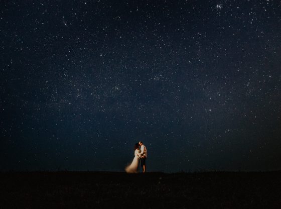 man and woman standing under the night sky