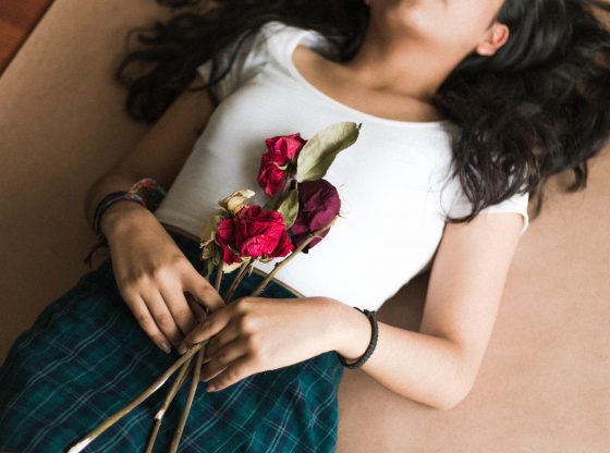 woman laying on floor holding roses