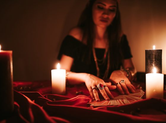 Young female fortune teller is looking into tarot cards