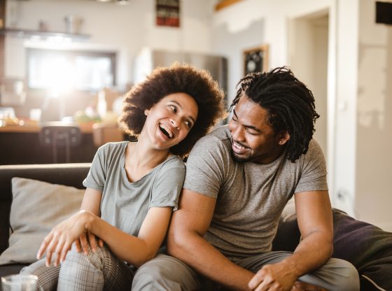 Cheerful African American couple communicating in the living room.