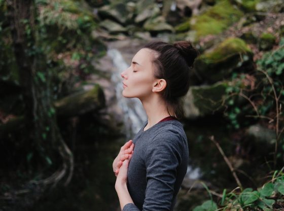 woman looking serene in nature with eyes closed