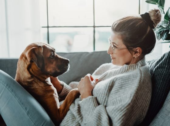 Woman cuddles with her dog at home