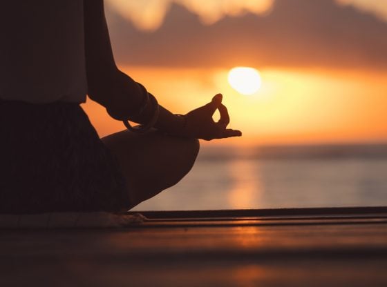 Young woman practicing yoga on the beach