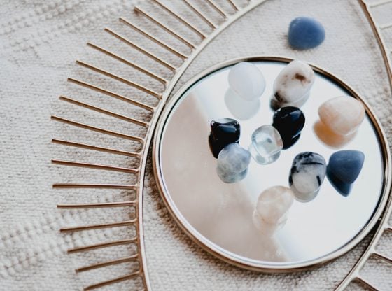 Recently cleansed crystals sit on an eye-shaped mirror.